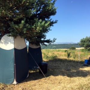 Bivouac chevaux, tente toilettes sèches, tente douche et réserves d'eau dans les poubelles noires qui chauffent au soleil (ou pas :-))