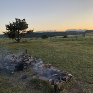 Bivouac chevaux, grillade en cours avec coucher de soleil sur le massif du Sancy