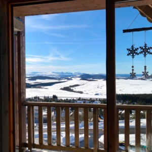 T3 Lamadado à Super-Besse, salon et terrasse avec une vue dégagée sur le Cézallier et le massif du Cantal