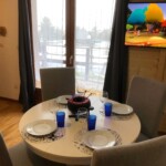 T3 Lamarmotte à Super-Besse, salle à manger avec appareil à fondue, télé 43" et terrasse avec vue sur la piscine enneigée